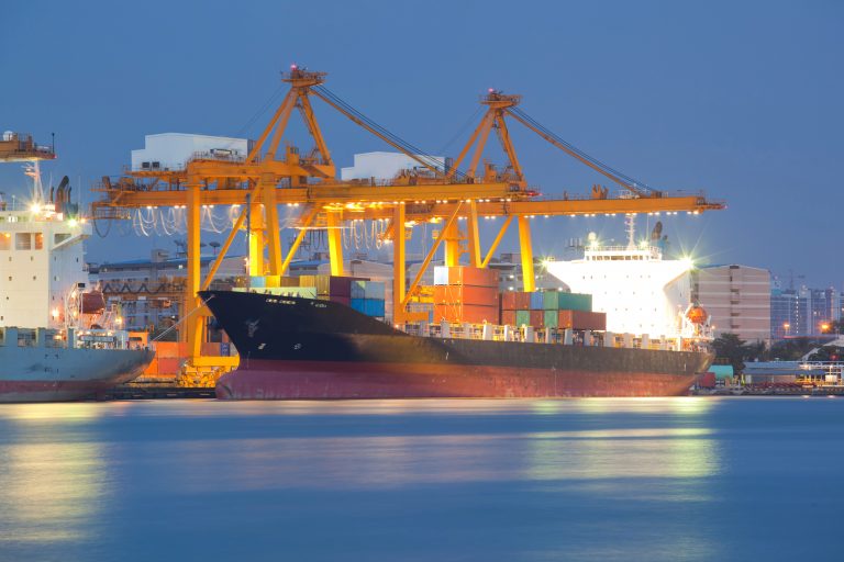 Boat with shipping containers sailing across the ocean