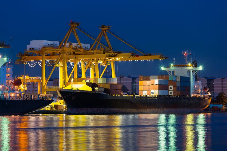 Ship with cargo traveling in the ocean at night